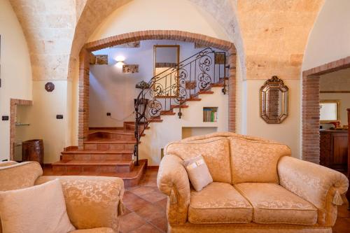 a living room with a couch and a staircase at Dimora La Reggia in Mesagne