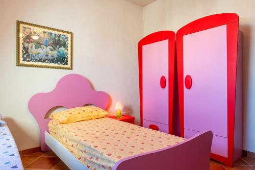 a bedroom with a bed with pink and purple cabinets at Dimora La Reggia in Mesagne