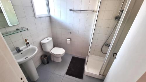 a bathroom with a toilet and a sink and a shower at Lovely 1BR in Old Town - City Center & 4min to Beach in Scala