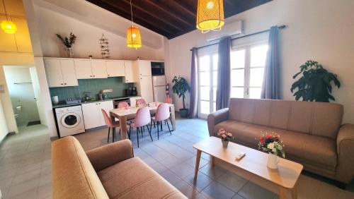 a living room with a couch and a table and a kitchen at Lovely 1BR in Old Town - City Center & 4min to Beach in Scala