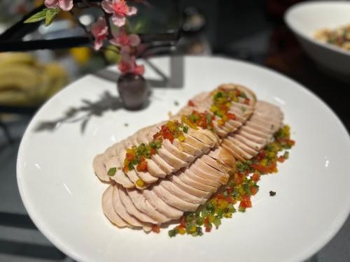 a white plate topped with meat with sauce and salsa at Guangzhou Southern Airlines Pearl Airport Hotel- Free shuttle bus to airport in Guangzhou