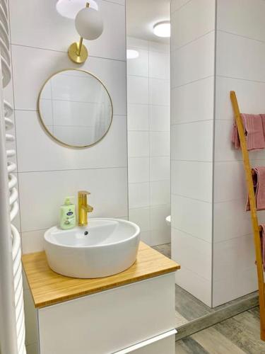 une salle de bain blanche avec un lavabo et un miroir dans l'établissement Appart Melvyn Chanael - proche gare, à Saint-Louis