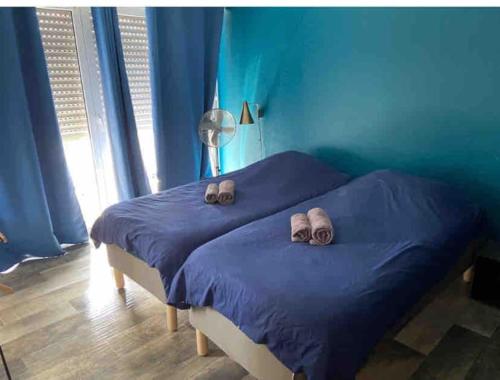 une chambre avec un lit avec deux pantoufles dessus dans l'établissement Appart Melvyn Chanael - proche gare, à Saint-Louis