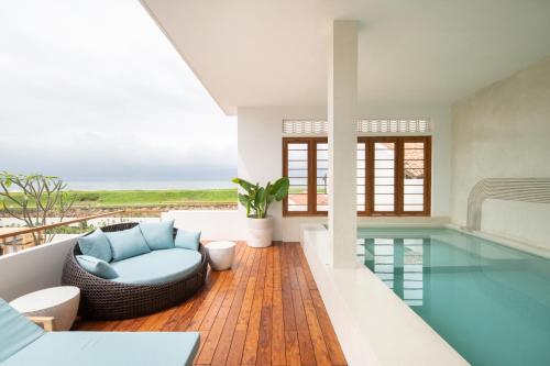 a house with a swimming pool with a blue couch at The Charleston in Galle