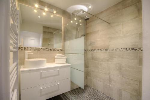 une salle de bain avec un lavabo et une douche avec un miroir dans l'établissement Le Campu Latinu, à Lama