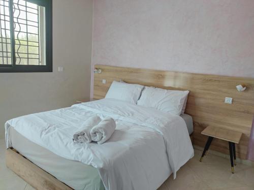 a bedroom with a large bed with white sheets at Airport Oasis Stay 15min to Rabat in Sale