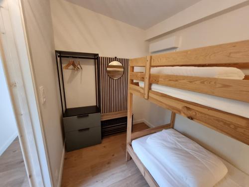 une chambre avec deux lits superposés et un miroir dans l'établissement Au Pied de la Dune, accès privé à la plage, à Saint-Georges-de-Didonne