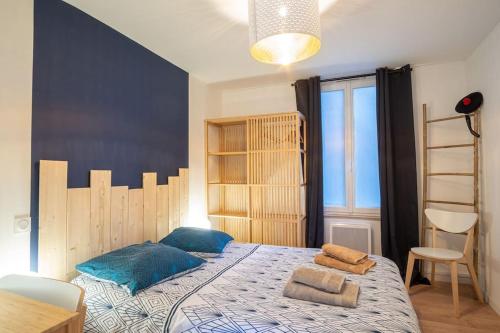 une chambre avec un grand lit avec des oreillers bleus dessus dans l'établissement Le Saphir - 150m de la Plage, à Étretat
