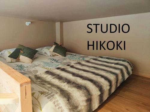 Una cama en una habitación con un cartel que lee Studio hikiki en Studio Hikoki, en Dinan