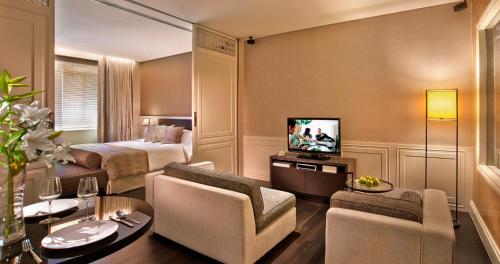 a hotel room with a bed and a television at Ascott Raffles Place Singapore in Singapore