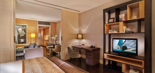 a hotel room with a bed and a television at Ascott Raffles Place Singapore in Singapore