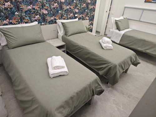 Home Ad Messinium في بومباي: سريرين في غرفة عليها مناشف