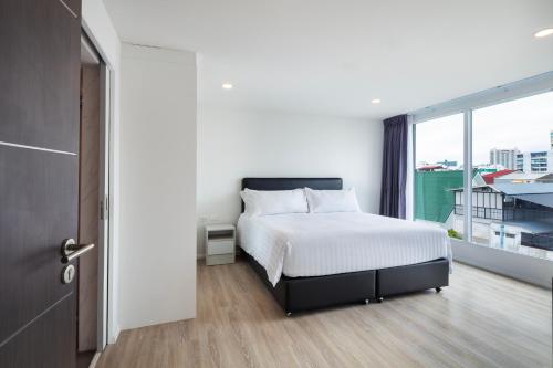 Postel nebo postele na pokoji v ubytování The Rizin Hotel Phratamnak