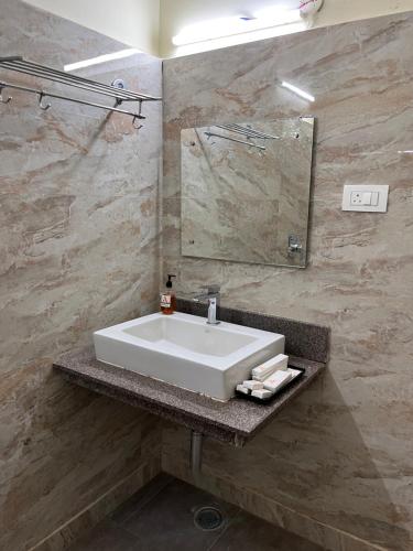 a bathroom with a white sink and a mirror at Ananya Comfortss in Hospet