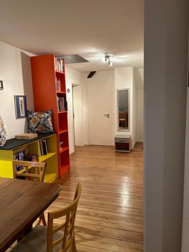 - un salon avec une table, des chaises et une étagère dans l'établissement Salutho, à Sélestat