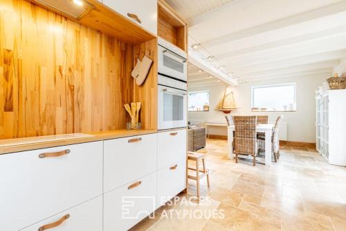 une cuisine avec des placards blancs et une salle à manger dans l'établissement Maison avec terrasse au centre de Dolus d'Oléron, à Dolus-d'Oléron
