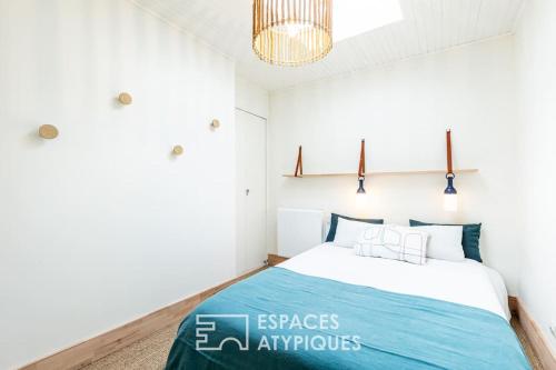 ein Schlafzimmer mit einem Bett und einem Kronleuchter in der Unterkunft Maison avec terrasse au centre de Dolus d'Oléron in Dolus-d'Oléron