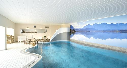 a swimming pool with a view of a lake at Victor's Seehotel Weingärtner Bostalsee in Bosen-Eckelhausen