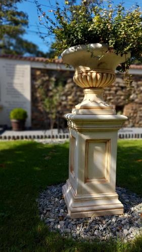 a large gold vase sitting on a pile of rocks at Conacul Poetilor in Gura Rîului