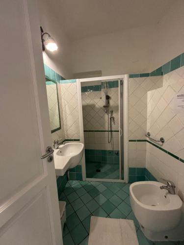 a bathroom with a sink and a toilet and a shower at Villa La Rosa in Filicudi