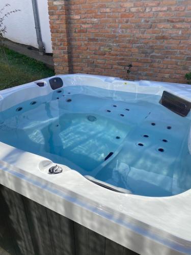 a jacuzzi tub in front of a brick wall at Kuća za odmor u prirodi NINA Jezero Orahovica in Duzluk