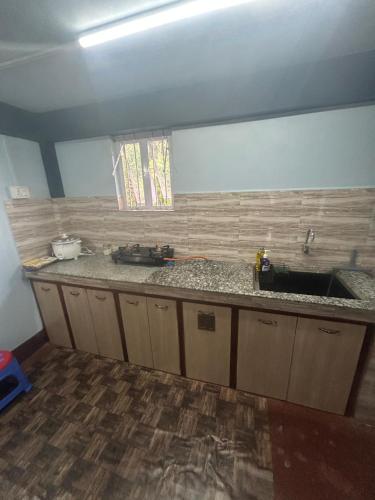 a kitchen with a sink and a counter top at Serenity Homestay Shillong in Shillong