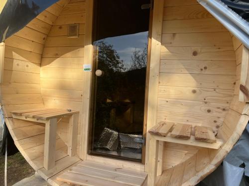 a wooden sauna with a window and two benches at Kuća za odmor u prirodi NINA Jezero Orahovica in Duzluk