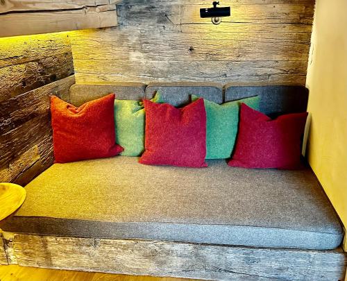a couch with four colorful pillows on it at Design Apartment Villa Anna Kitzbühel in Kitzbühel