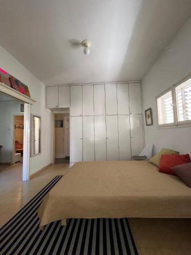 a bedroom with a large bed with white cabinets at Tel-Aviv Vibe Apartment in Tel Aviv