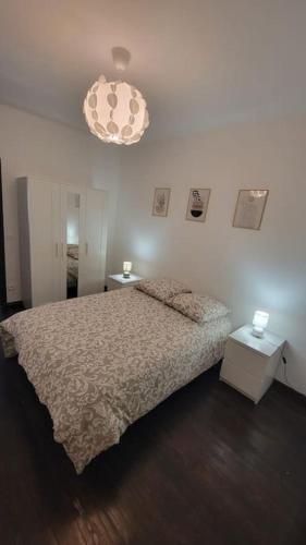 une chambre avec un lit et un lustre dans l'établissement Charmant appartement en cœur de ville, à Armentières