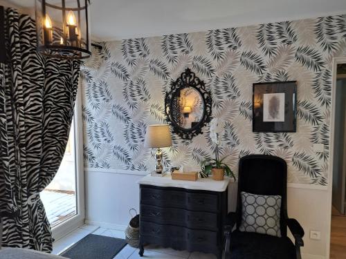 a room with a dresser and a mirror on a wall at Le Logis Fleurs et jardins de Pitry in Thierville