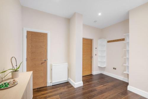 a living room with white walls and wooden floors at New 3Bed in Knightsbridge in London