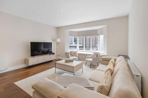 a living room with a couch and a tv at New 3Bed in Knightsbridge in London