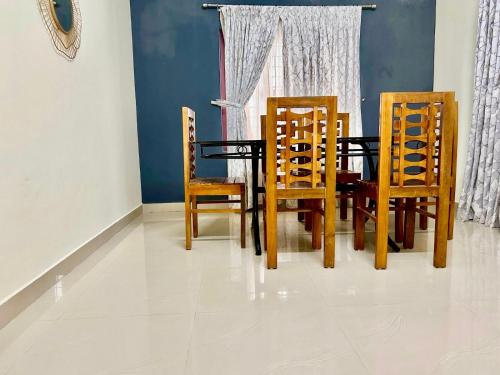a dining room with a table and four chairs at Krishnakripa - Luxury Private Villa Near Guruvayoor Temple in Guruvāyūr