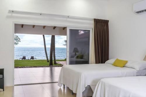 ein Schlafzimmer mit zwei Betten und Meerblick in der Unterkunft Casa Las Doroteo in El Sunzal