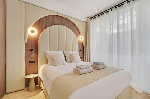 une chambre avec un grand lit avec des serviettes dessus dans l'établissement Modern Flat - 2BR-6P - Northern Paris, à Paris