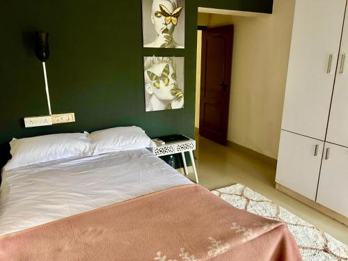 a bedroom with a bed and a green wall at Krishnakripa - Luxury Private Villa Near Guruvayoor Temple in Guruvāyūr