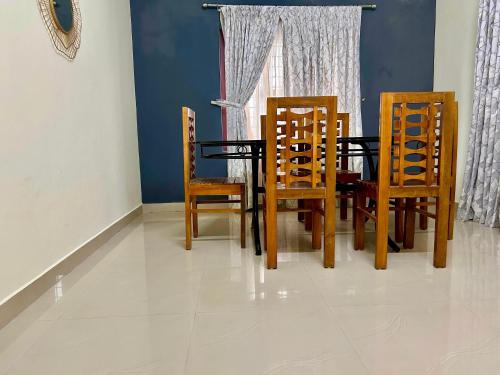 a dining room with a table and four chairs at Krishnakripa - Luxury Private Villa Near Guruvayoor Temple in Guruvāyūr