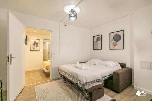 - une chambre blanche avec un lit et un canapé dans l'établissement MBA - Beslay - Splendide Appartement Paris Centre, à Paris