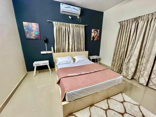 a bedroom with a bed and a tv on the wall at Krishnakripa - Luxury Private Villa Near Guruvayoor Temple in Guruvāyūr