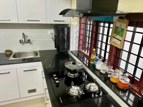 a kitchen counter with a stove with a pot on it at Krishnakripa - Luxury Private Villa Near Guruvayoor Temple in Guruvāyūr