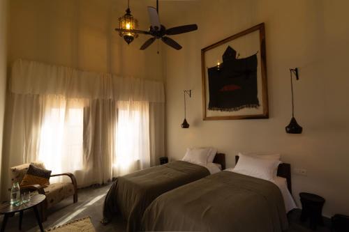 a bedroom with two beds and a ceiling fan at Maison 250 - Adult Only in Essaouira