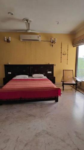 a bedroom with a bed and a chair in a room at Basti House - Boutique Homestay in Lucknow