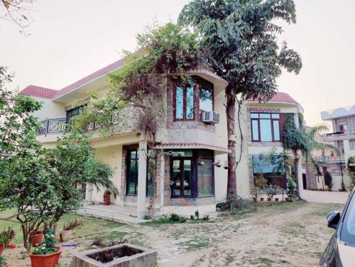a large house with trees in front of it at Basti House - Boutique Homestay in Lucknow