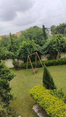 an empty swing set in a yard with trees at Basti House - Boutique Homestay in Lucknow