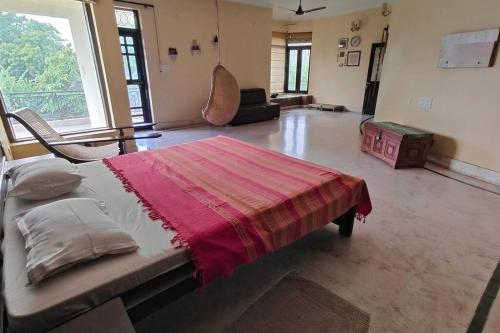 a large room with a bed with a red blanket on it at Basti House - Boutique Homestay in Lucknow