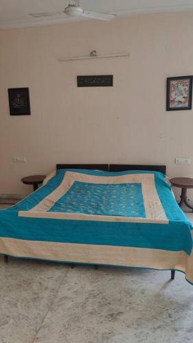 a bedroom with a bed with a blue comforter at Basti House - Boutique Homestay in Lucknow