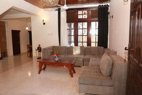 a living room with a couch and a coffee table at alBum by sEa World in Matara