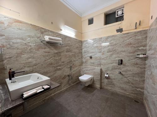 a bathroom with a sink and a toilet and a tub at Ananya Comfortss in Hospet