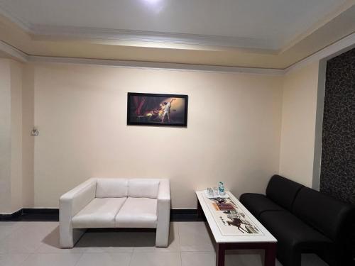 a living room with a couch and a table at Ananya Comfortss in Hospet